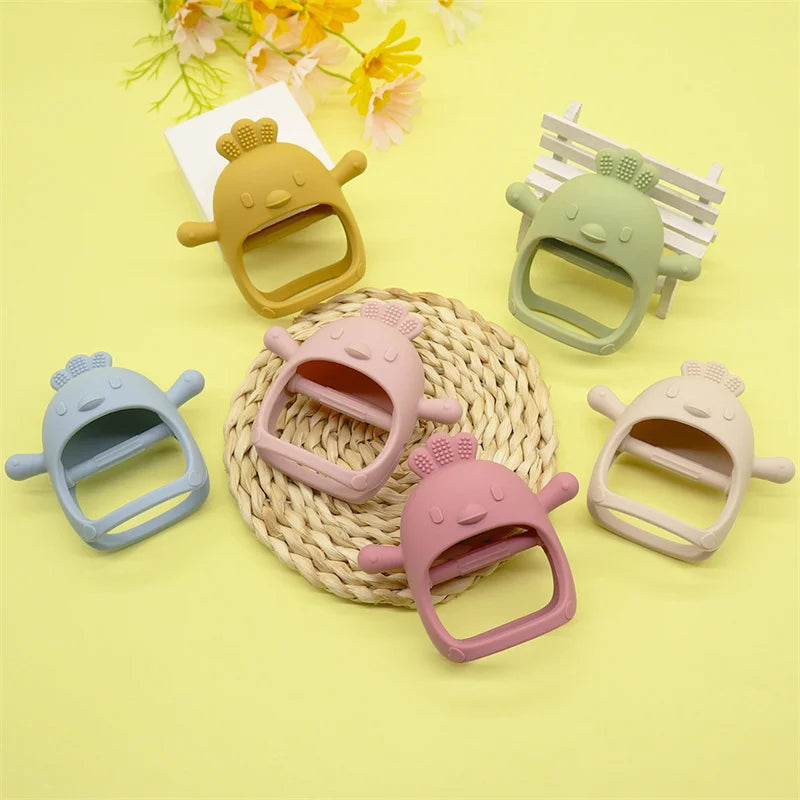 Colorful cartoon chicken-shaped teethers in soft shades of yellow, green, blue, pink, and cream, arranged on a yellow background with decorative flowers.