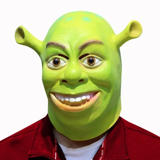 Person wearing a green ogre mask featuring large ears and a wide grin, dressed in a red jacket against a plain white background.