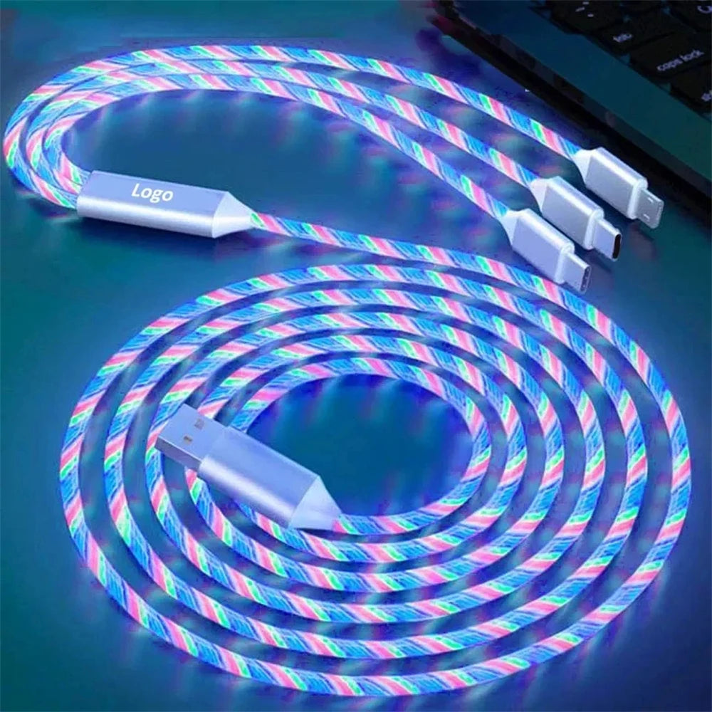 A glowing multi-colored braided charging cable with USB on one end and three connectors on the other, displayed against a dark background near the corner of a laptop.