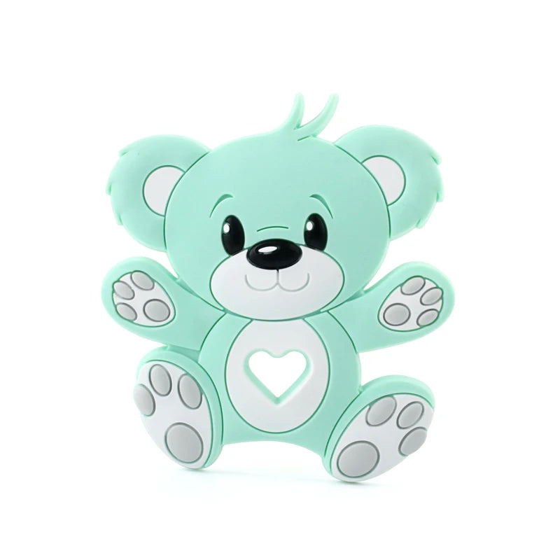 Cute mint green teddy bear with big eyes and a heart-shaped cutout on its belly. It has oval ears and paws with gray pads, sitting against a plain white background.