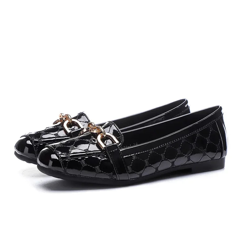 Shiny black loafers with a textured pattern and metallic link accents on the front, set against a plain white background.