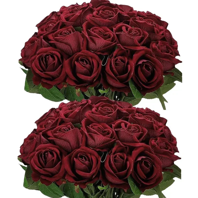Two bundles of dark red roses with lush green leaves, arranged closely together against a white background, highlighting their velvety petals and rich color.