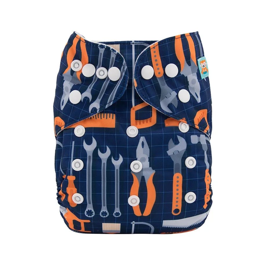 Reusable cloth diaper with a dark blue grid pattern featuring colorful tool designs, including wrenches, pliers, and saws. Secured with white snap buttons.