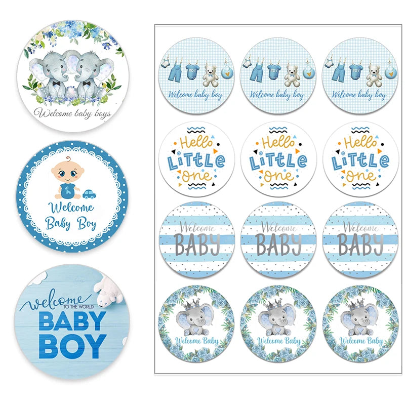 Assorted round baby shower stickers with blue, white, and gray designs. Images feature elephants, baby clothes, a teddy bear, and phrases like "Welcome Baby Boy" and "Hello Little One."