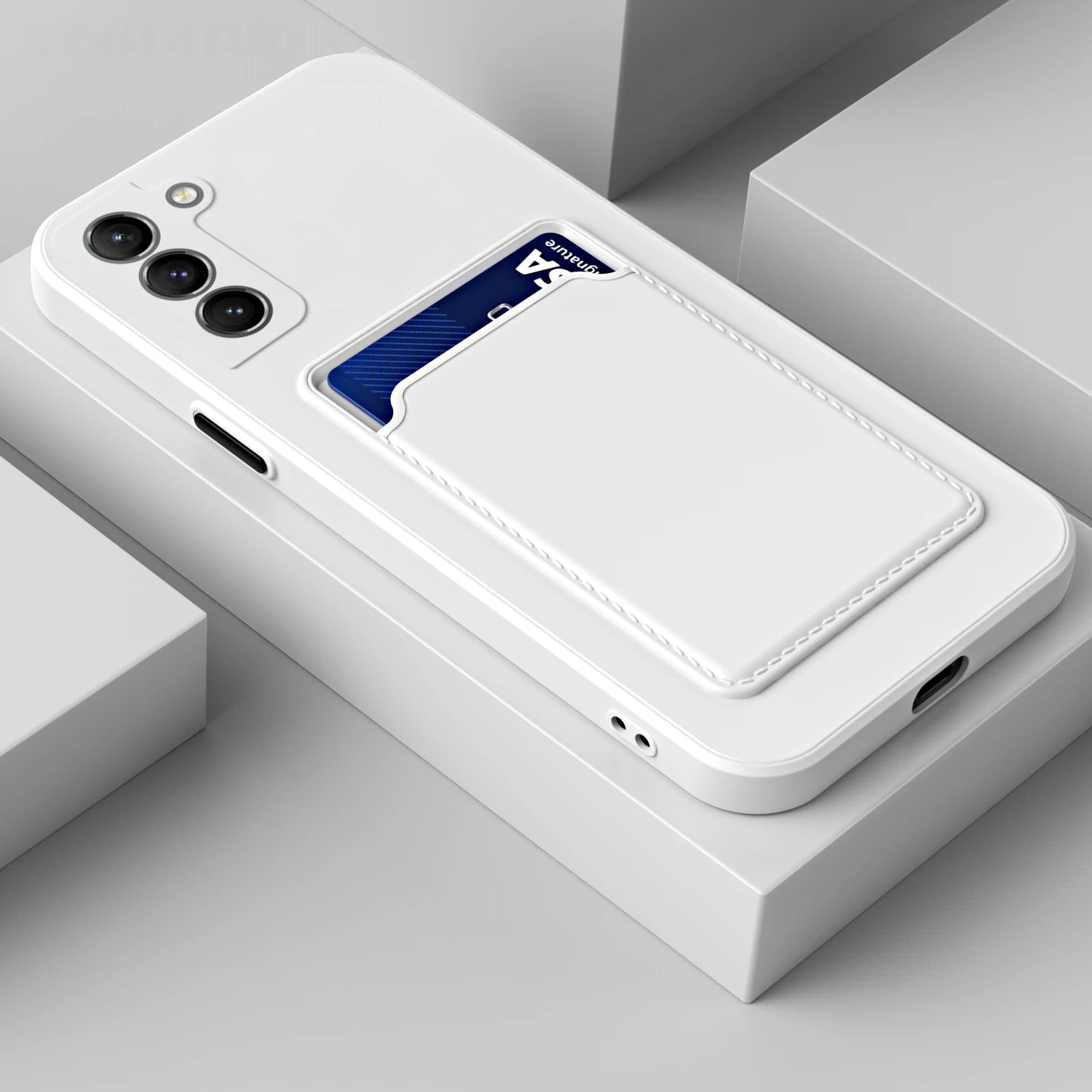 White smartphone case with three camera lenses and a built-in card slot holding a blue card. The case is placed on a geometric white surface.