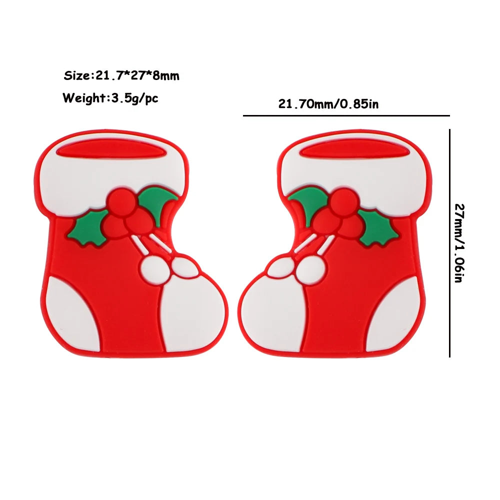 Two red and white Christmas stocking decorations with holly leaves and berries, measuring 21.7mm by 27mm. Each weighs 3.5g.