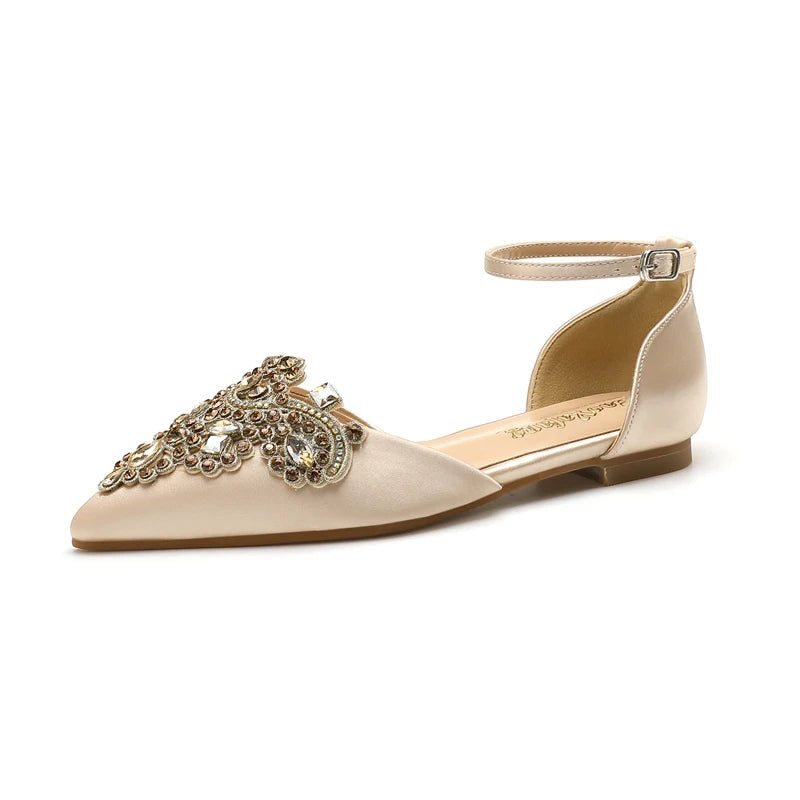 Elegant beige satin flat shoe with pointed toe, adorned with intricate gold embroidery and rhinestones. Features an ankle strap with a buckle closure.