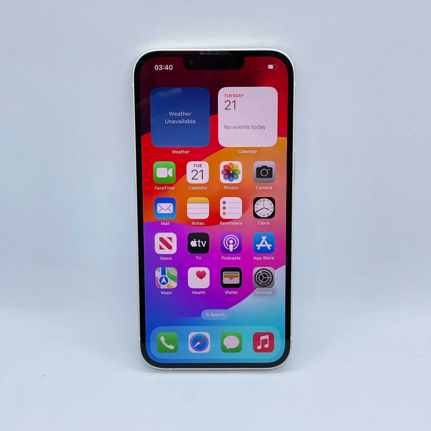 A smartphone displaying the home screen with various app icons, including Weather, Calendar, Mail, and Settings. The time shown is 03:40, and the background is a colorful gradient.