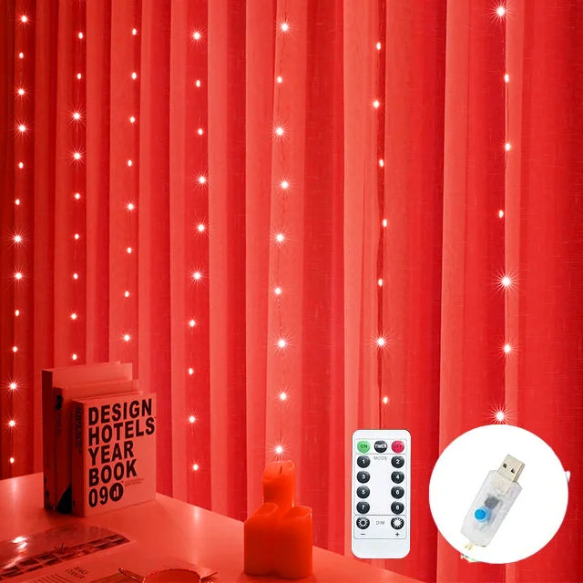 Red curtains adorned with twinkling string lights beside a table with a book and candle. A remote and USB device are shown for light control.