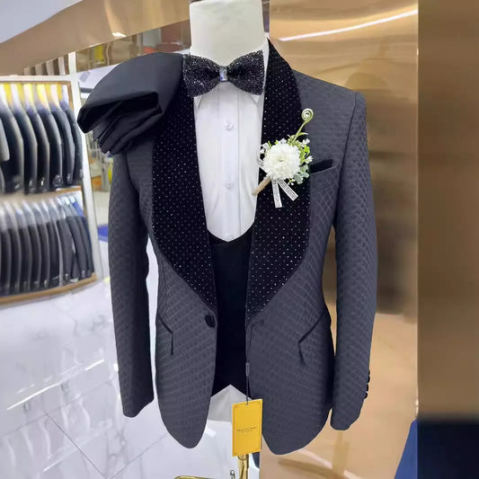 Gray tuxedo jacket with black textured lapels, white shirt, and glittery bow tie. A white boutonniere is pinned on the jacket. A matching black fabric is draped over the shoulder.