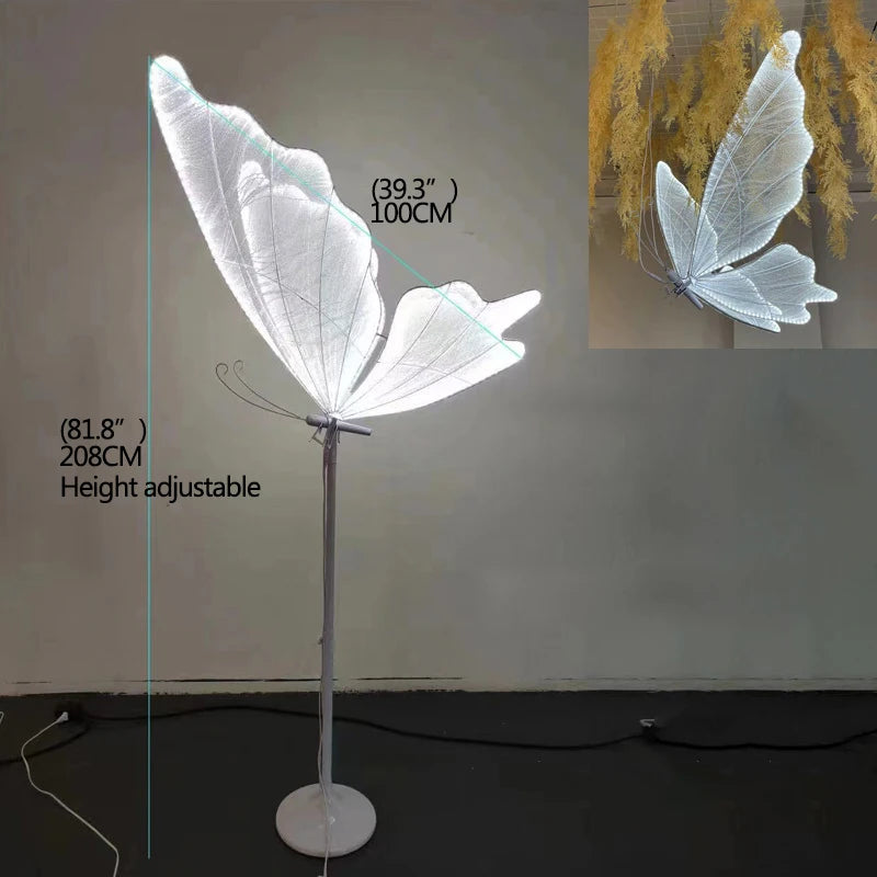 A floor lamp with large illuminated butterfly wings, adjustable height ranging from 81.8 inches to 39.3 inches. The lamp is displayed against a plain wall with an inset view.