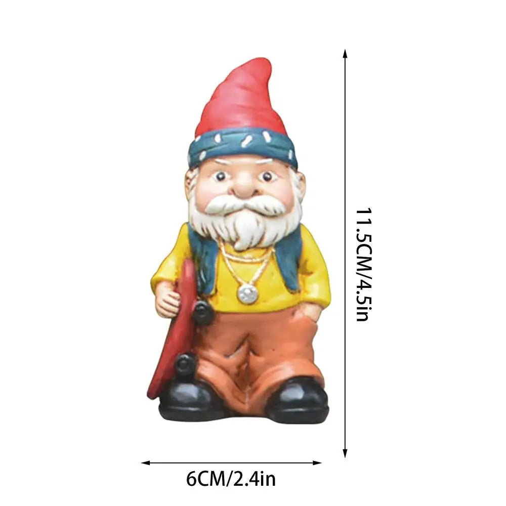 Small garden gnome figurine with a red hat, blue bandana, yellow shirt, and orange pants, holding a red skateboard. Dimensions: 11.5 cm tall and 6 cm wide.