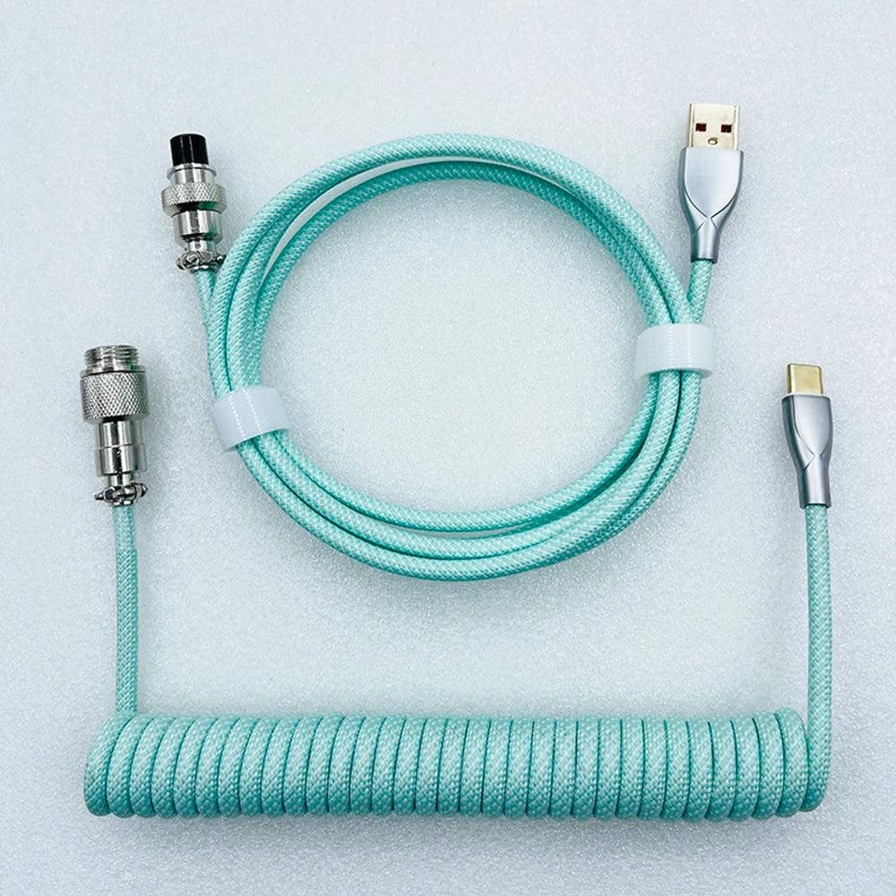 A teal coiled USB cable with silver connectors, featuring USB-A and USB-C ends. The cable is neatly coiled and partially wrapped with Velcro for organization.