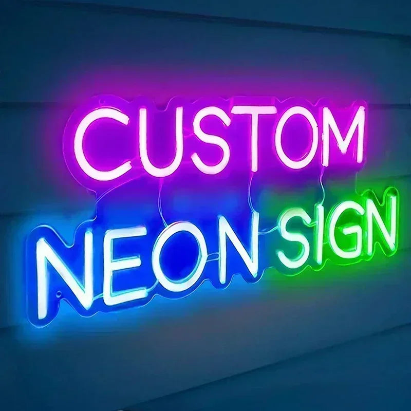 Neon sign with the words "CUSTOM NEON SIGN" in vibrant pink, blue, and green letters against a dark background, creating a colorful glow.
