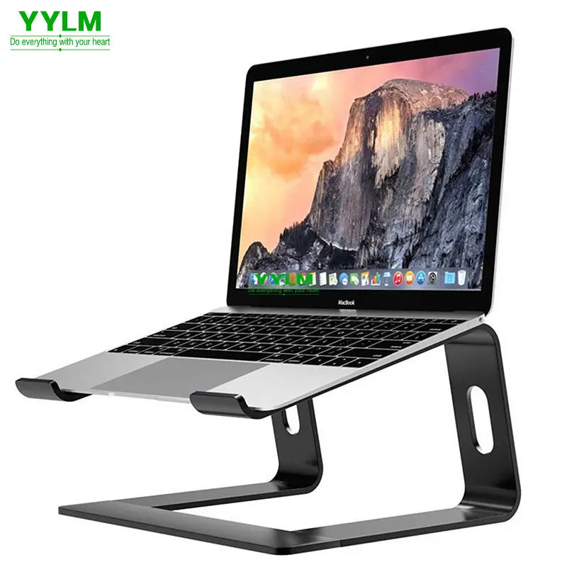 A laptop with a mountainous wallpaper is placed on a sleek black metal stand, elevating the device and providing an ergonomic setup. The logo "YYLM" is in the top left corner.
