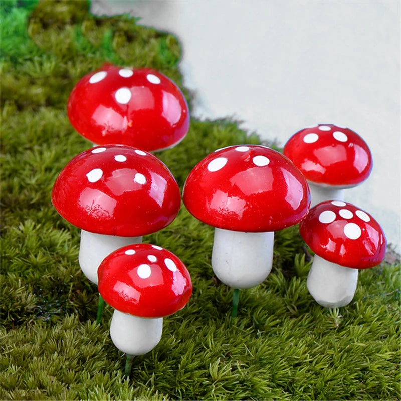 Six small, glossy, red mushrooms with white spots stand on green moss, resembling classic toadstools.
