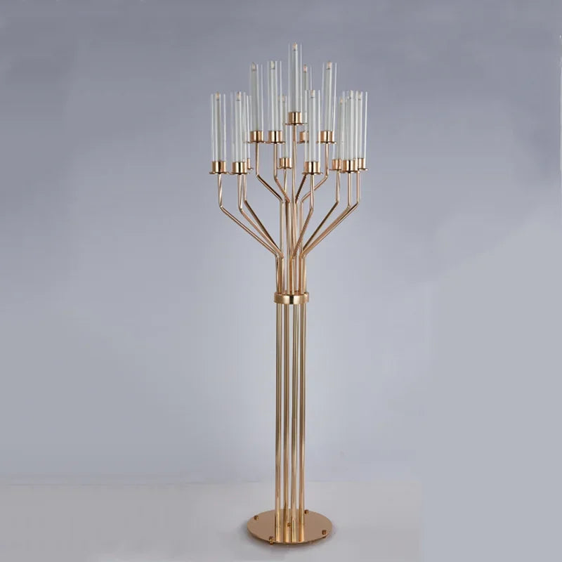 Elegant gold metal candelabrum with multiple arms, each holding a tall glass candle holder. The modern design stands on a circular base against a neutral background.