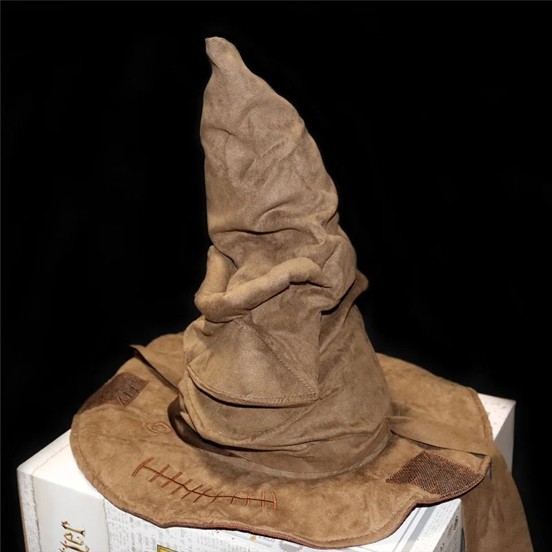 A brown, worn-out sorting hat with visible stitches and folds sits atop a stack of books against a black background.