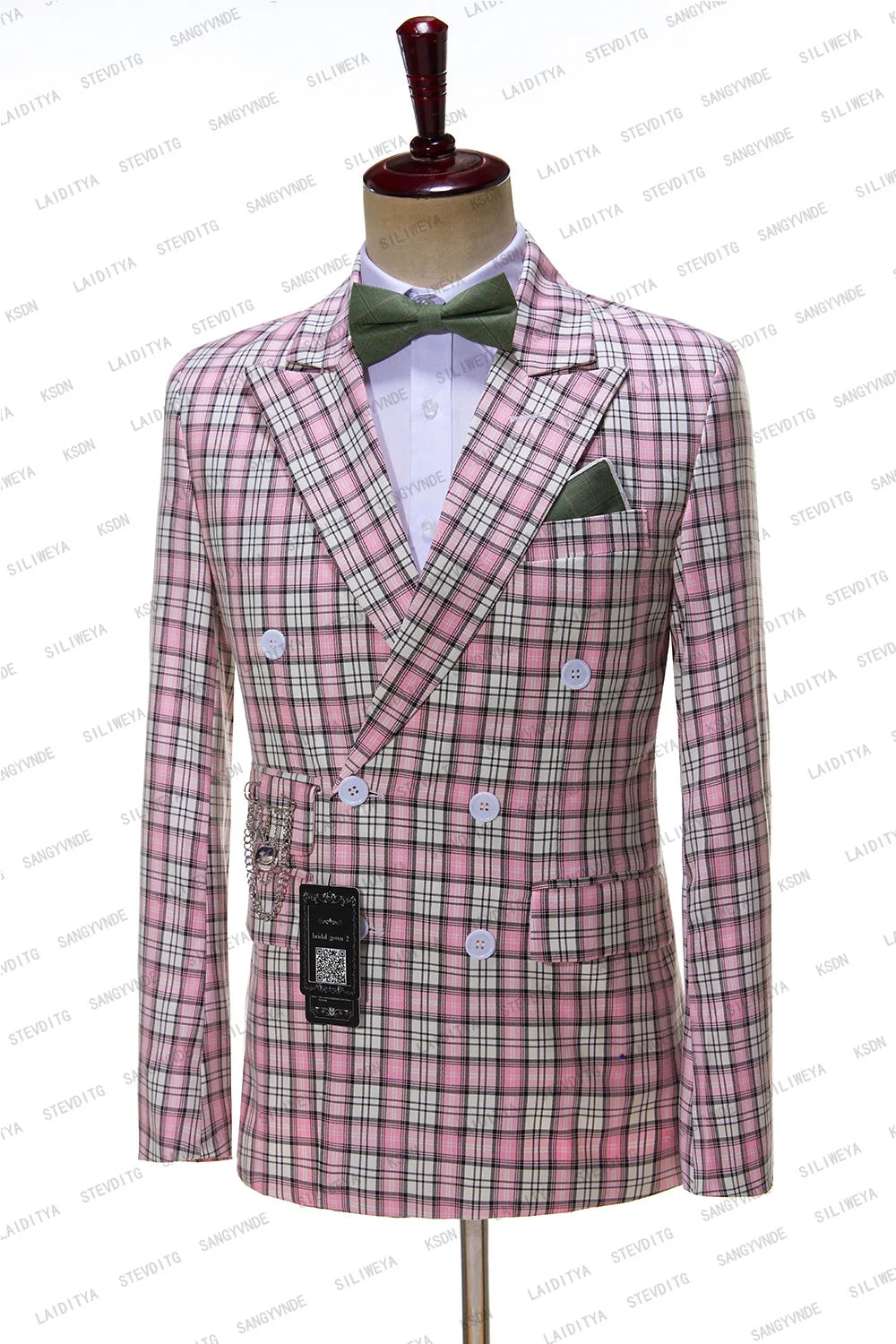 Plaid pink and white double-breasted suit jacket on a mannequin, featuring white buttons, a green bow tie, and pocket square. Background has repeating watermark text.