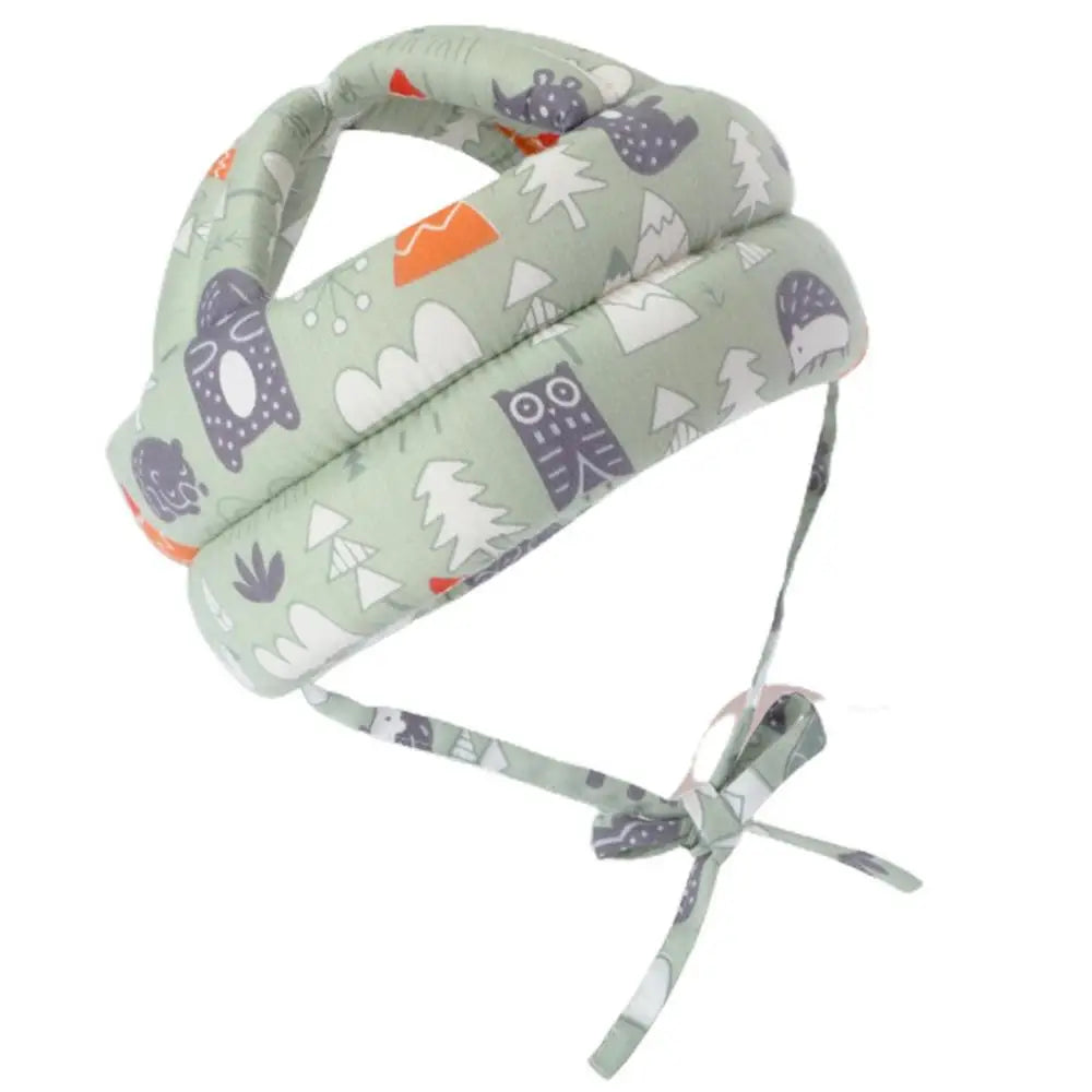 Soft green toddler helmet with cute animal and tree prints. Features adjustable straps for a secure fit, providing safety and comfort.