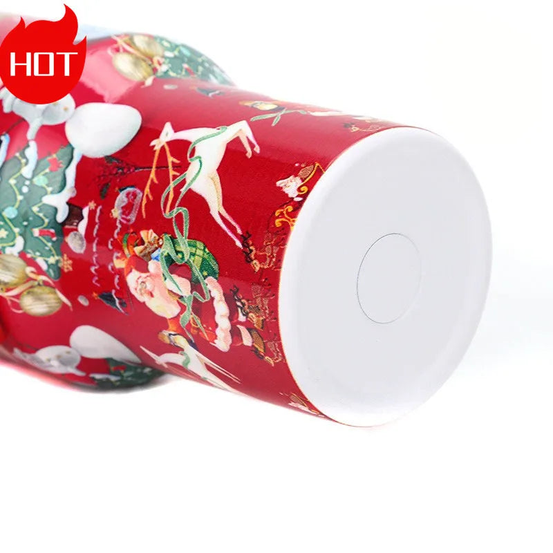 Red thermos flask with festive Christmas designs, featuring Santa, snowmen, and reindeer on a vibrant background. The bottom is white. "HOT" label in the top left corner.