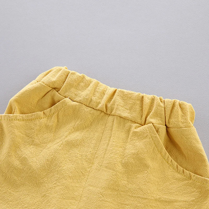 Close-up of a yellow fabric with a crinkled texture, featuring an elastic waistband and visible seam.