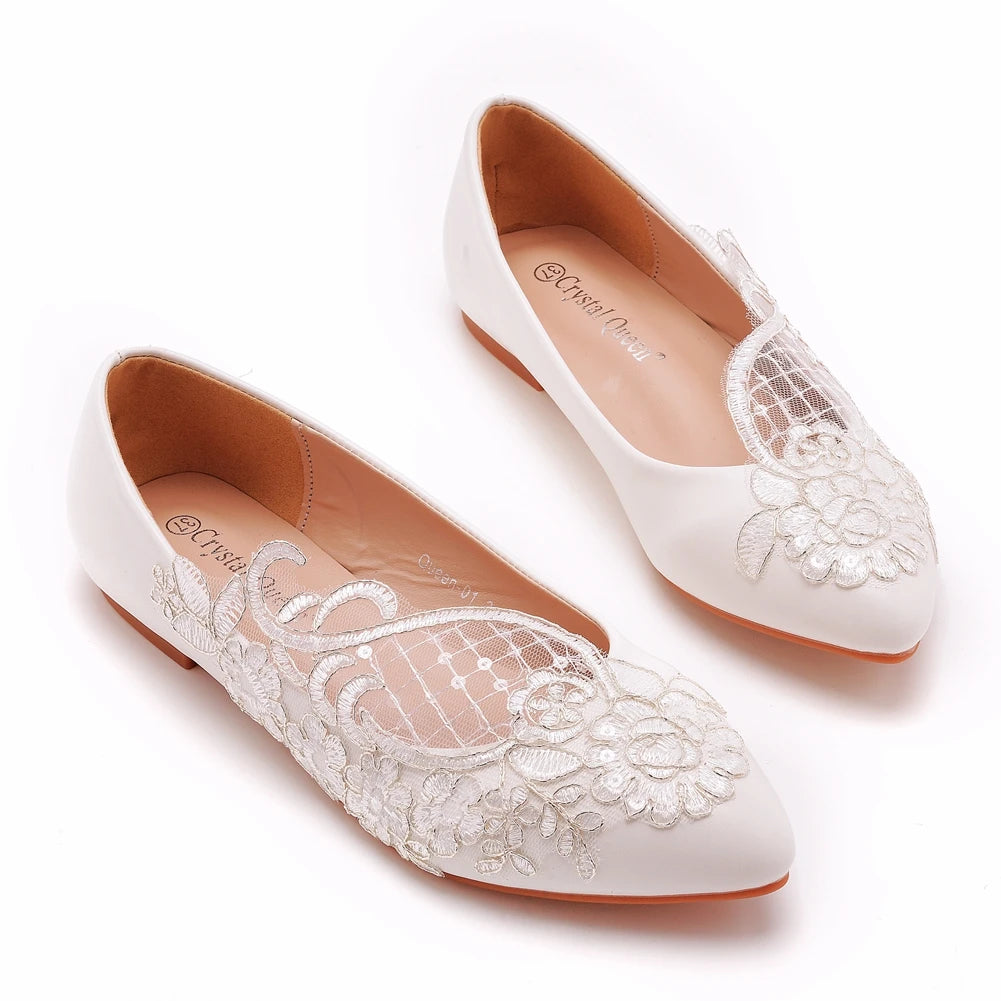 Elegant white flats with intricate lace and floral embroidery on the upper, featuring a pointed toe and tan inner lining.