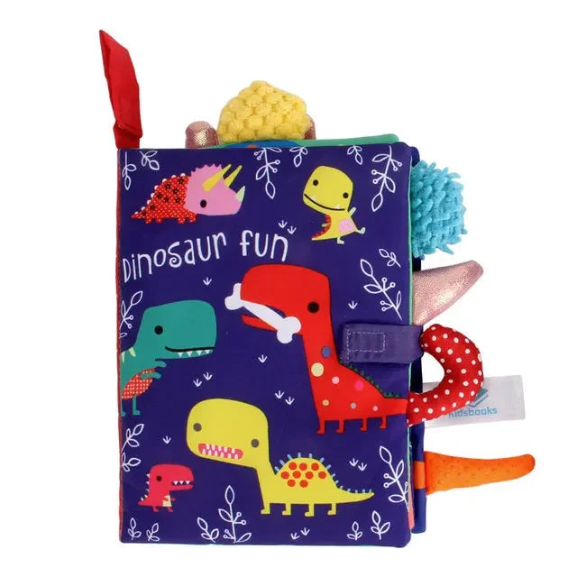 Colorful children's fabric book titled "Dinosaur Fun" with cartoon dinosaurs on a purple cover. Features various textures, tabs, and elements protruding from the edges.