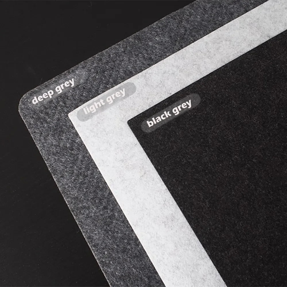 Three rectangular felt sheets overlap on a dark surface, labeled "deep grey," "light grey," and "black grey," showcasing different shades of grey.