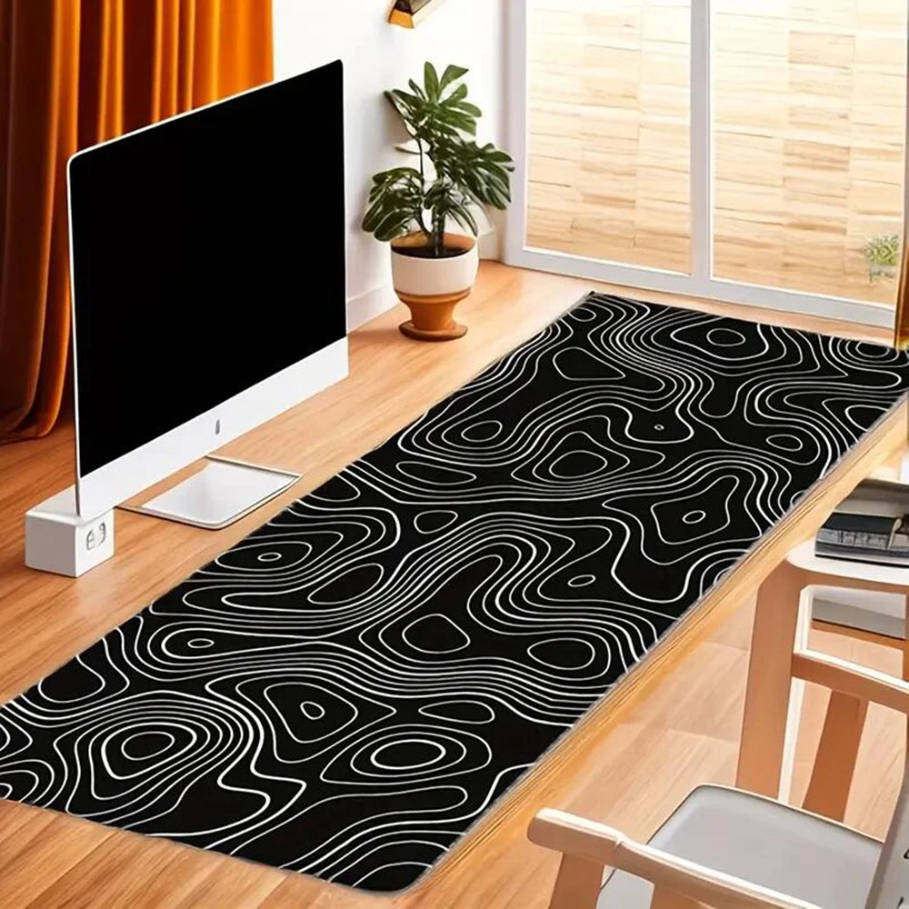 Modern office with a computer, wooden desk, and chair. A long black rug with white abstract lines runs along the floor. Potted plant and large window with curtains in the background.