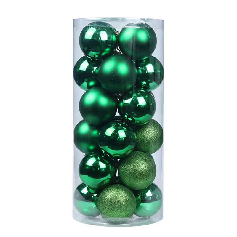 A transparent plastic cylinder contains shiny and matte green Christmas ornaments of various finishes.