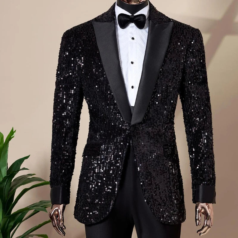 Sequin-covered black tuxedo with satin lapels, a white dress shirt with black buttons, and a black bow tie. Mannequin display with a green plant visible in the background.