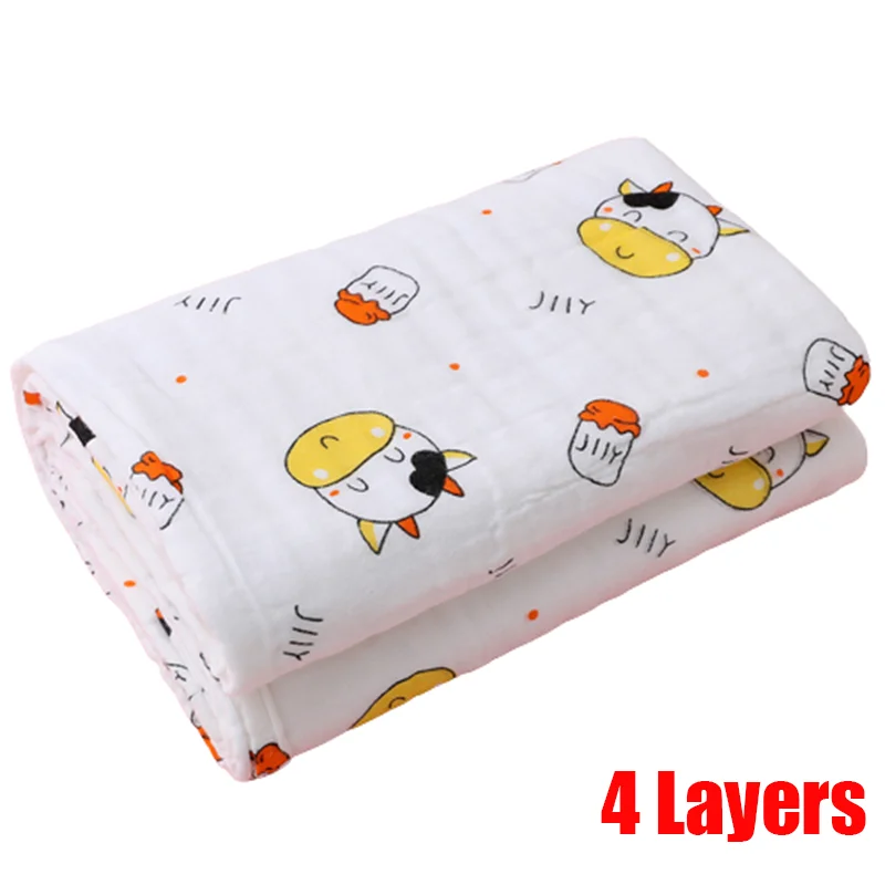 Folded white blanket with cartoon cow and milk bottle print, featuring orange and yellow accents. Text reads "4 Layers" in bold red lettering at the bottom right.