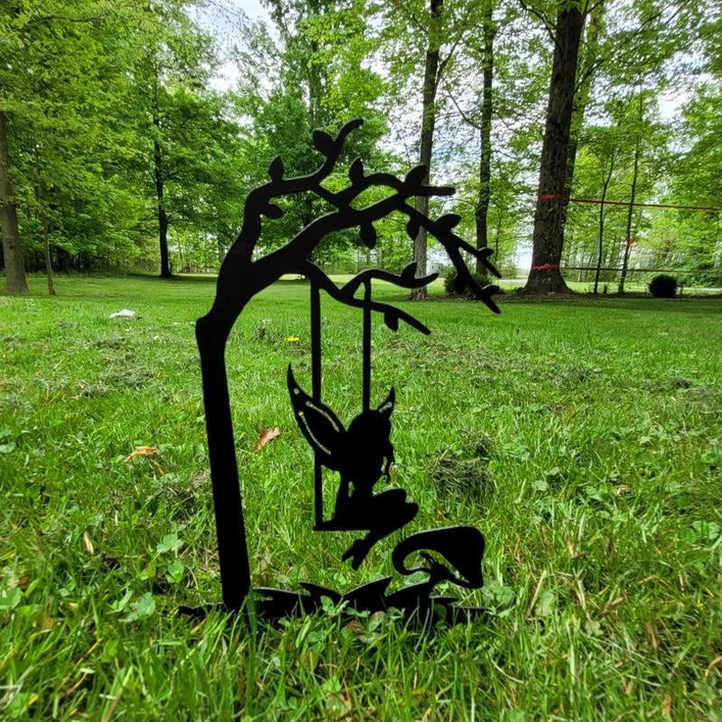 Silhouette of a fairy sitting on a swing attached to a tree branch, set against a vibrant, green park backdrop with tall trees and a lush grass lawn.