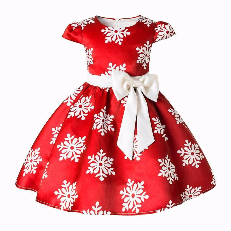 Red dress with white snowflake patterns, featuring short sleeves and a white bow at the waist. The dress is elegant and festive, suitable for holiday occasions.