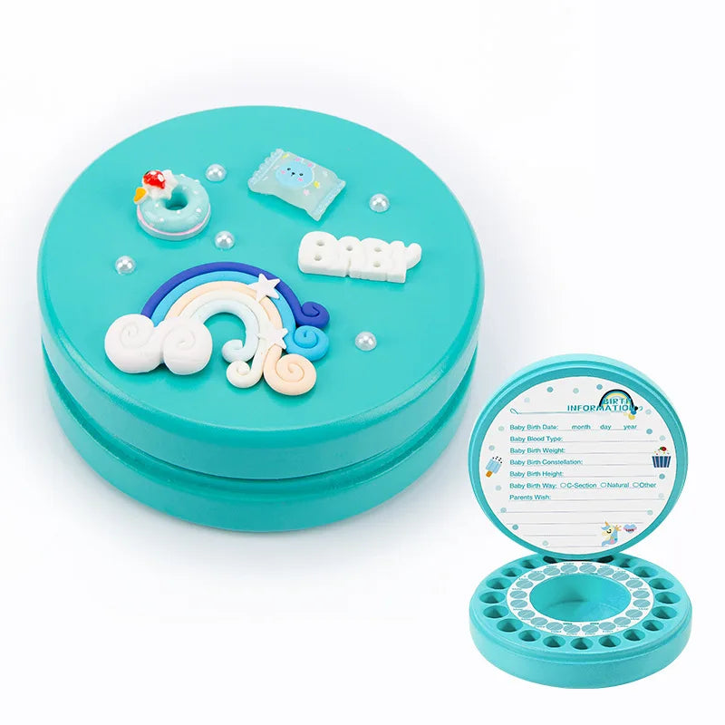 Teal baby tooth keepsake box with a removable lid, adorned with a rainbow, clouds, a blue seal, and the word "Baby." Inside has compartments for teeth and a birth info card.