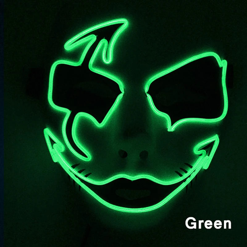 Glowing green neon mask with sinister smile and sharp eyebrow design. The dark background highlights its bright, eerie contours.