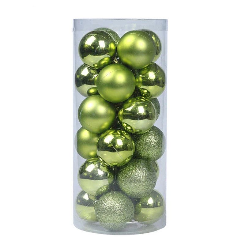 A clear cylindrical container holds shiny, matte, and glittering green Christmas ornaments, stacked closely together.