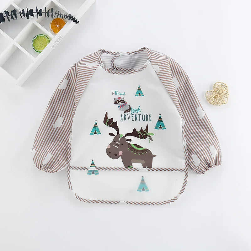 Children's bib with brown striped sleeves and a playful design of a moose and raccoon among green tents. Text reads "Be Brave Seek Adventure" with nature-themed details.
