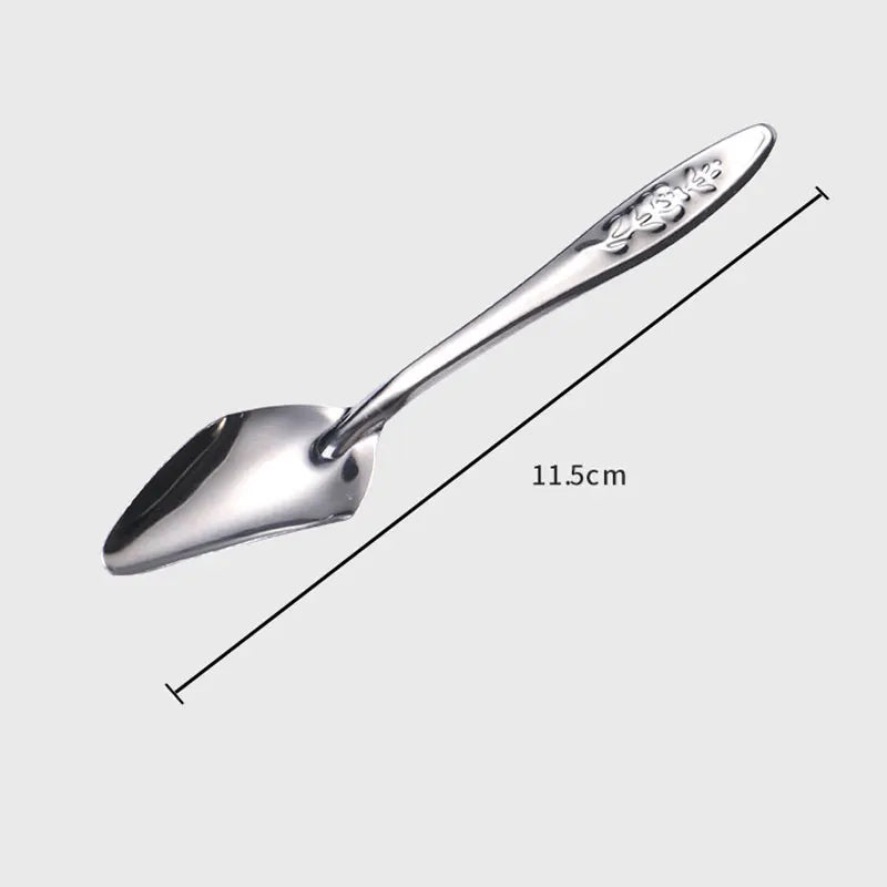 A 11.5 cm long stainless steel shovel-shaped spoon with ornamental floral engravings on the handle, displayed on a light gray background at an angle.