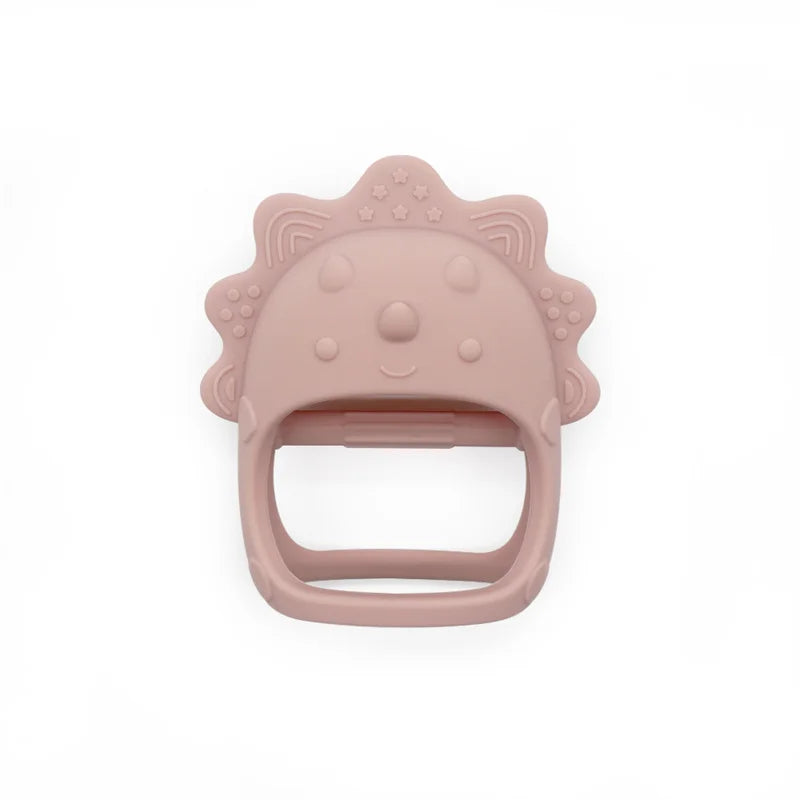 Cute pink teether shaped like a smiling animal face with textured edges for grip. Made from soft, safe material, ideal for soothing babies' gums.