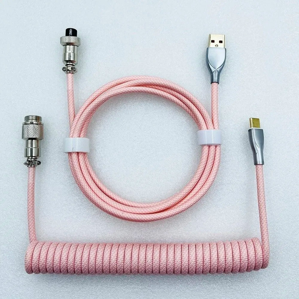 Pink coiled mechanical keyboard cable with metal connectors and a braided design, featuring USB-A and USB-C ends, neatly arranged on a white background.