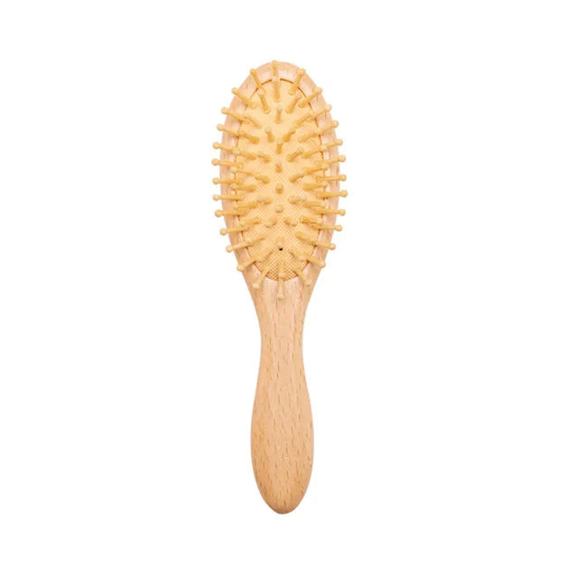 A wooden baby hairbrush with a light wood handle and soft bristles. The bristles are set on an oval cushioned base, offering gentle grooming for infants.