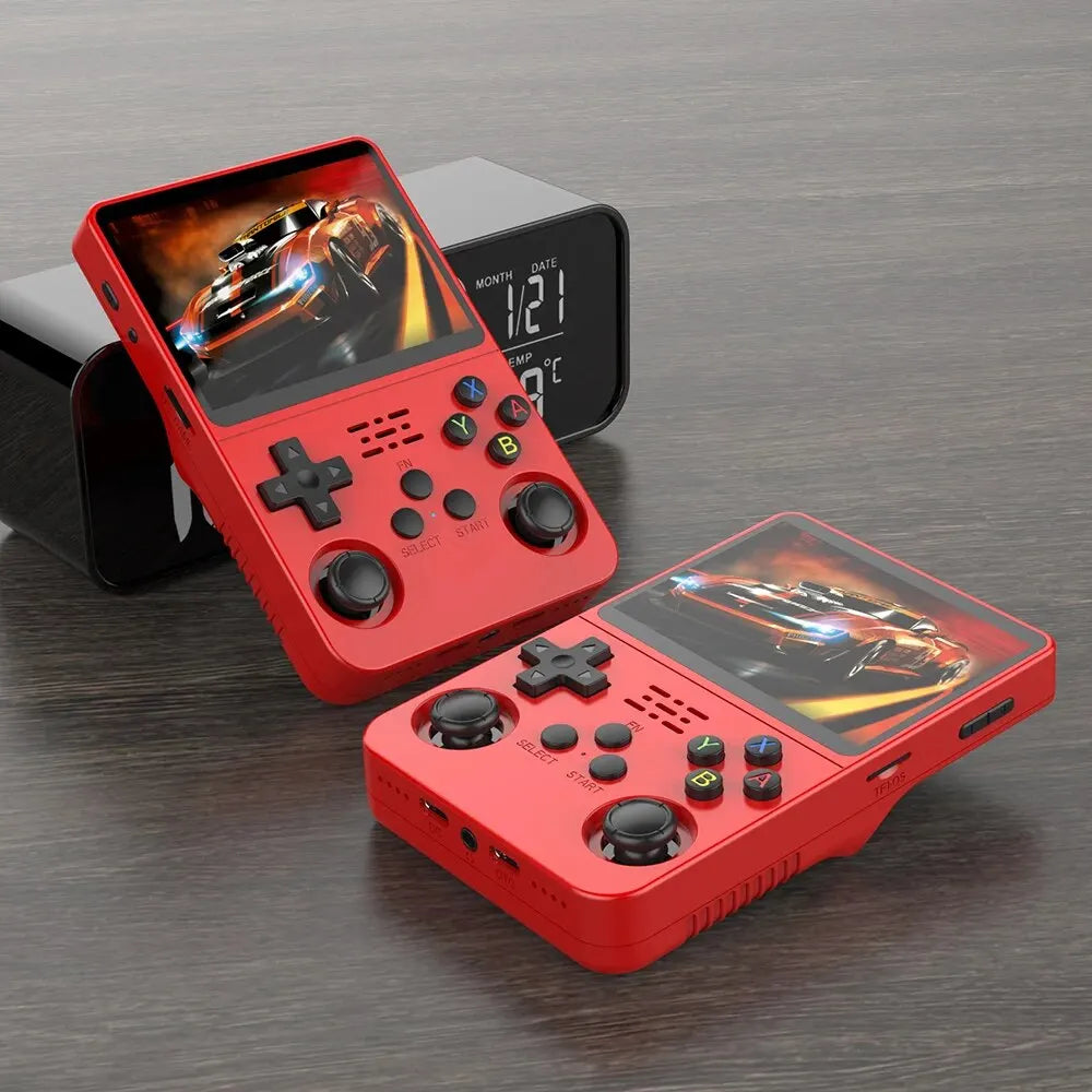 Two Faron R36S Retro Handheld Consoles (64GB Games) with vibrant IPS screens and nostalgic design rest on wood beside a digital clock. These red portables feature racing games, buttons, and joysticks for classic gaming fun.