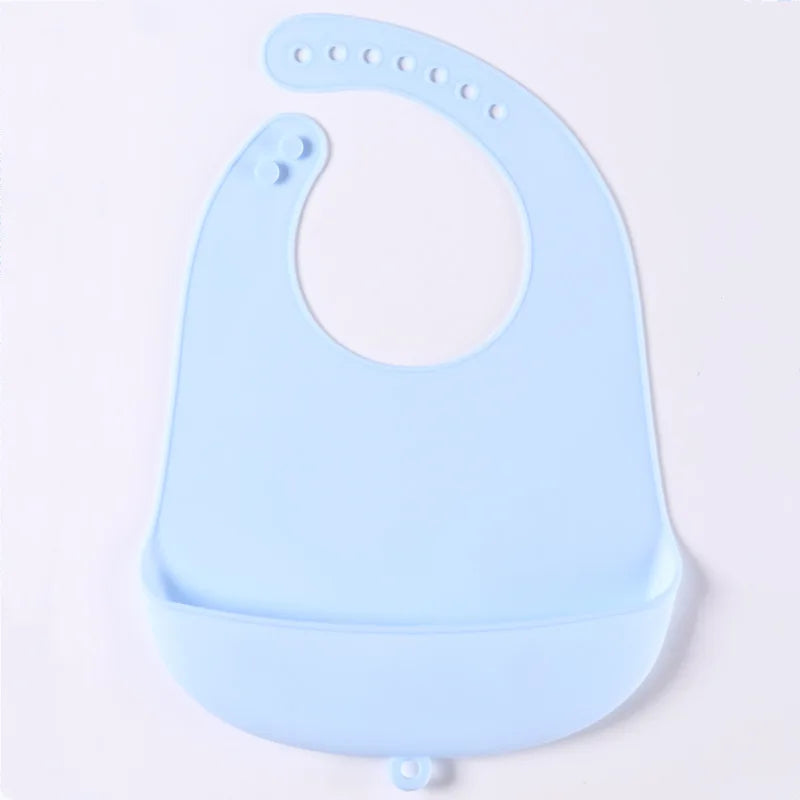 Light blue silicone baby bib with adjustable neck fasteners and a food-catching pocket.