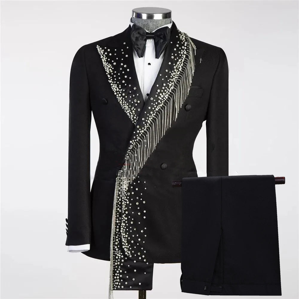Black tuxedo with pearl and crystal embellishments on one side, paired with black trousers. The jacket features a double-breasted design, satin lapel, and bowtie.
