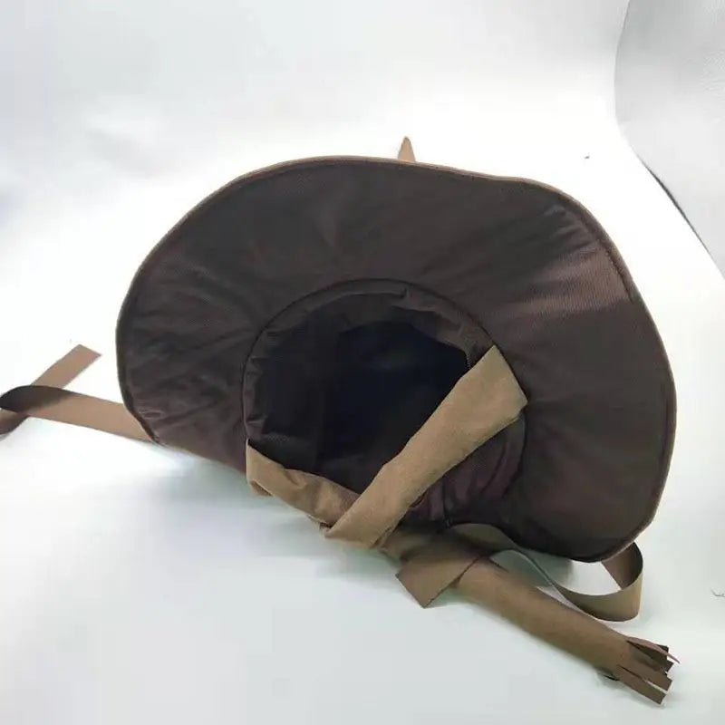 Brown dog hat with floppy brim and ear flaps on a white background. The hat has tie straps and is shaped to fit comfortably on a pet's head.