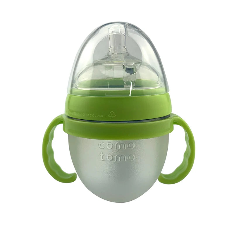 Green silicone baby bottle with dual handles, a wide neck, and a clear plastic cap. The body is frosted and the brand name is embossed on the front.