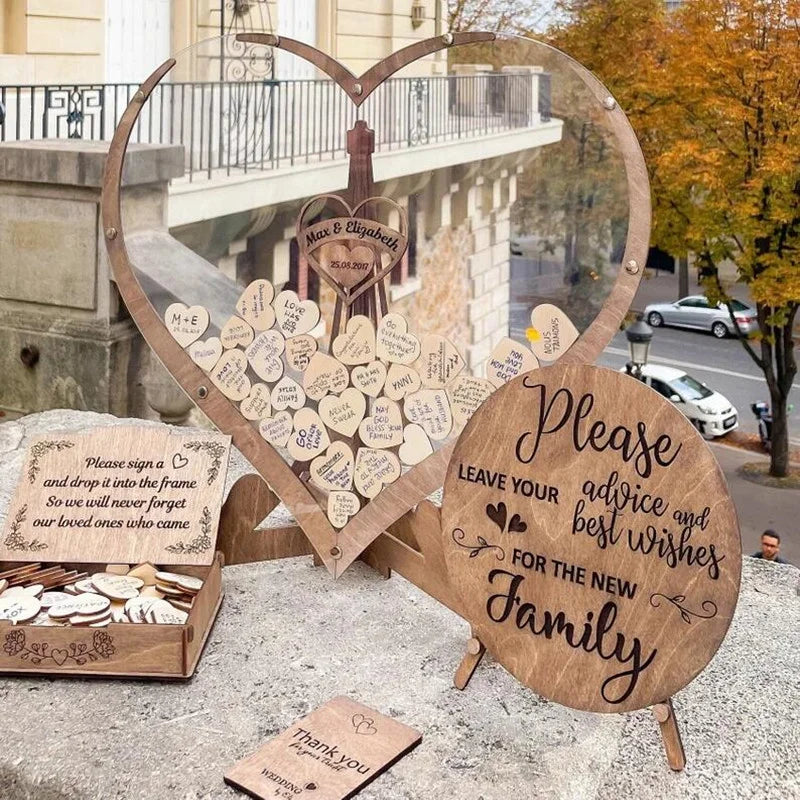 Heart-shaped wedding guest book with wooden hearts for messages, set on a stone ledge. Sign reads, "Please leave your advice and best wishes for the new family."