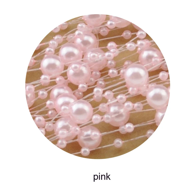 Close-up of pink pearls strung on translucent threads, arranged intricately against a soft background. The pearls vary in size, creating a delicate and decorative pattern.